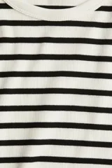 Remera de punto acanalado a rayas horizontales blancas y negras, de corte ajustado, cuello redondo y mangas cortas.