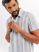 Camisa de manga corta efecto lino de Cuatroases, con estampado de rayas verticales en color azul y fondo beige. Presenta cuello camisero clásico y cierre frontal con botones blancos.