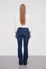 Pantalon jean de tiro alto con corte flare y terminación desflecada en el ruedo. Presenta un diseño clásico de cinco bolsillos con costuras en contraste.