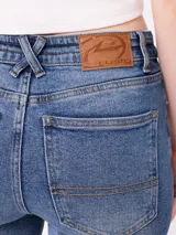 Jean de corte acampanado (flare fit) en color azul lavado, con tiro medio, cierre frontal con botón y bolsillos laterales y traseros.