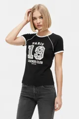 Remera de algodón manga corta color negro, con cuello a la base y ribetes blancos en cuello y mangas. Presenta un estampado frontal con tipografía y número con diseño de encaje.