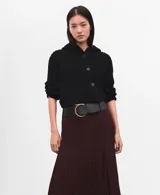 Chaqueta de punto negra con capucha, manga larga y cierre frontal de botones.
