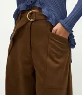Pantalón de corte barrel con cintura estructurada, trabillas y cinto ajustable con hebilla metálica. Presenta diseño de piernas anchas con recortes laterales y bolsillos frontales.