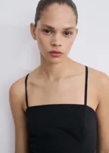 Vestido corto negro de corte evasé, con escote cuadrado, tirantes finos cruzados en la espalda y detalle de pinzas en el frente.