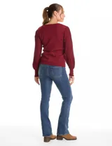 Buzo de tejido lurex marca Nanette, con cuello redondo y mangas largas con diseño plisado. Presenta puños ajustados con aplique de botones decorativos.