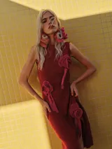 Vestido midi de lurex marrón con brillo sutil, cuello a la base, sin mangas, con apliques de flores en relieve y tajo lateral en la falda.