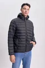 Campera negra capitoneada con capucha y cierre frontal.