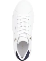 Zapatillas de estilo tenis Tommy Hilfiger, confeccionadas en piel blanca con suela de plataforma de caucho. Presentan detalles en color azul marino en el talón y una línea decorativa en tono granate, junto con ojales metálicos y logo de la marca en el lateral.