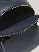 Mochila Tommy Hilfiger azul marino con diseño de monograma jacquard, bolsillo frontal con cierre y detalles metálicos dorados.