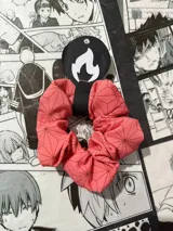 Scrunchie de tela color rosa con estampado geométrico de hexágonos y triángulos en color marrón. Inspirado en el kimono de Nezuko Kamado del anime Kimetsu no Yaiba (Demon Slayer).
