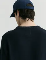 Sweater de punto con escote redondo, confeccionado en algodón con textura de punto fantasía en cuerpo y mangas, y terminaciones en punto canalé en cuello y puños.
