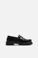 Mocasín de vestir fabricado en piel de alta calidad con detalle de antifaz en el empeine, horma redonda y suela track con ligero volumen.