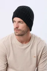 Gorro tejido de punto grueso con diseño acanalado y vuelta en el borde. Incluye una pequeña etiqueta de cuero sintético en el lateral.