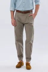 Pantalón bombacha de campo color caqui, de corte tradicional con pinzas en la cintura y botamanga ajustada con botones.