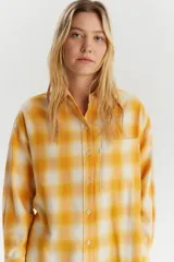 Camisa de franela a cuadros amarillos y blancos, de corte recto y manga larga.