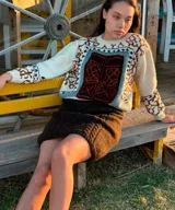 Sweater de lana merino color crudo, con cuello redondo y diseño geométrico tipo jacquard en el frente y las mangas.