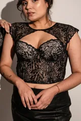 Corset negro con copas y aro, ballenas en la parte delantera, confeccionado en puntilla elastizada y microtul. Detalle de broche en el escote.