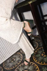 Sandalia de tacón cuadrado medio, confeccionada en tela tipo terciopelo color bordó, con tira delantera simple y pulsera ajustable al tobillo con hebilla metálica.