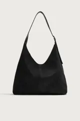 Bolso de hombro tipo shopper en color negro, con diseño liso y cierre magnético. Cuenta con un bolsillo interior con cremallera y asa ajustable.