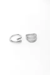 Set de dos anillos plateados; uno de diseño abierto y envolvente, y el otro formado por múltiples aros finos unidos.