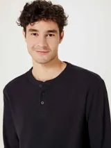 Camiseta de manga larga con cuello henley y cierre frontal de tres botones, confeccionada en tejido de textura waffle.