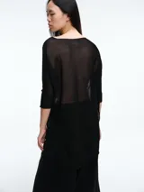 Sweater tipo túnica de tejido liviano con sutil transparencia y acabado brillante. Presenta escote en V, mangas largas relajadas y un corte amplio con largo asimétrico.