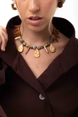 Collar corto de diseño artesanal compuesto por cuentas de cristal checo, piedras facetadas, gotas de nácar y piezas en forma de colmillo. Incluye cadena de acero quirúrgico para ajuste de largo.