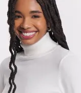 Polera de punto de manga larga con cuello alto, confeccionada en una mezcla de viscosa, poliéster y nylon. Presenta puños y ruedo acanalados.