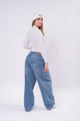 Jean baggy de tiro bajo en color celeste, con corte holgado y relajado, bolsillos traseros y etiqueta de cuero sintético en la pretina.