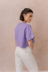 Remera crop color beige, de calce amplio, escote redondo y mangas cortas sueltas.