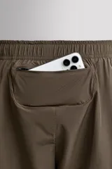 Shorts deportivos de entrenamiento Zara Athleticz, color beige, confeccionados en tejido técnico ligero y elástico con forro interior. Presentan cintura elástica ajustable, bolsillos frontales, bolsillo trasero de seguridad con cierre, aberturas laterales en el bajo y detalle de logo estampado en la pierna.