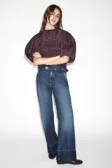 Jeans de tiro bajo con pernera recta y bajo con vuelta. Cuenta con cinco bolsillos y cierre frontal con cremallera y botones.