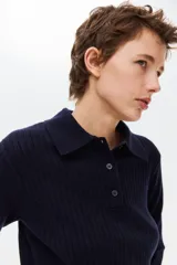 Top en punto acanalado de manga tres cuartos, color azul marino, con cuello polo y tapeta corta de botones.
