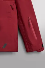 Cazadora deportiva de esquí con diseño bicolor en tonos negro y verde oliva. Presenta capucha amplia con visera, cierre frontal con cremallera termosellada, bolsillos frontales y en manga con cierres impermeables, y aberturas de ventilación en las axilas. Incluye faldón interior antinieve, puños ajustables y tecnología de rescate RECCO.