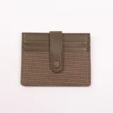 Tarjetero verde con diseño tejido y cierre con broche.