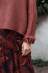 Falda larga de lino con estampado paisley en tonos marrón y naranja, diseño de corte irregular con volado en el ruedo y cierre invisible lateral.