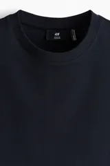 Remera de manga corta color negro, con cuello redondo y corte estándar. Confeccionada con fibra sintética COOLMAX para mayor transpirabilidad.