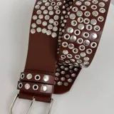 Cinto marrón de cuero sintético con tachas plateadas.