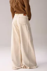 Pantalón wide leg de jean en tono azul, con diseño bicolor que combina paneles laterales en color blanco, bolsillos traseros appliqués y detalles de etiqueta de cuero con la marca.