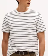 Remera de corte regular confeccionada en tejido de algodón y poliéster, con cuello redondo y mangas cortas. Presenta un diseño de rayas horizontales finas en relieve.