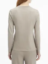 Remera gris de algodón regenerativo, corte slim, cuello redondo y manga larga. Logo pequeño de Calvin Klein debajo del cuello.