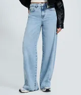 Pantalón de jean estilo wide leg con cintura media, cierre frontal con botón y cremallera, bolsillos funcionales y diseño de pierna amplia con recorte transversal.