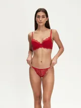 Soutien de encaje negro con diseño de copas con aros y bordes festoneados. Cuenta con breteles finos ajustables y un pequeño aplique metálico decorativo en la base de la copa.