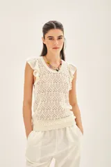 Musculosa de punto calado color crudo, con volados en las sisas y cuello redondo.