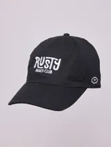 Gorro de visera negro de lona, con bordado frontal en blanco que dice "Rusty Beach Club" y un pequeño bordado de flor en el lateral.