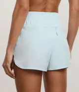 Bermuda deportiva Get Over modelo runner color beige, con cintura elástica, bajo redondeado y aberturas laterales. Cuenta con un pequeño bolsillo funcional trasero.