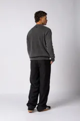 Sweater de punto grueso con textura waffle, de calce relajado y cuello redondo. Presenta puños y ruedo acanalados, con un pequeño parche con logo en el puño izquierdo.