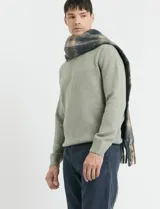 Sweater de punto en color verde claro, con cuello redondo y mangas largas. Presenta un diseño clásico de tejido liso con puños y ruedo acanalados.