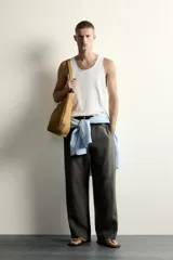Camiseta sin mangas tipo tank top de corte slim fit, confeccionada en tejido de algodón con elasticidad, cuello redondo amplio y vivos en tejido combinado a tono.