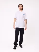 Remera de corte holgado color blanco, con estampa gráfica en la espalda que incluye el logo de la marca en tonos azul y gris.